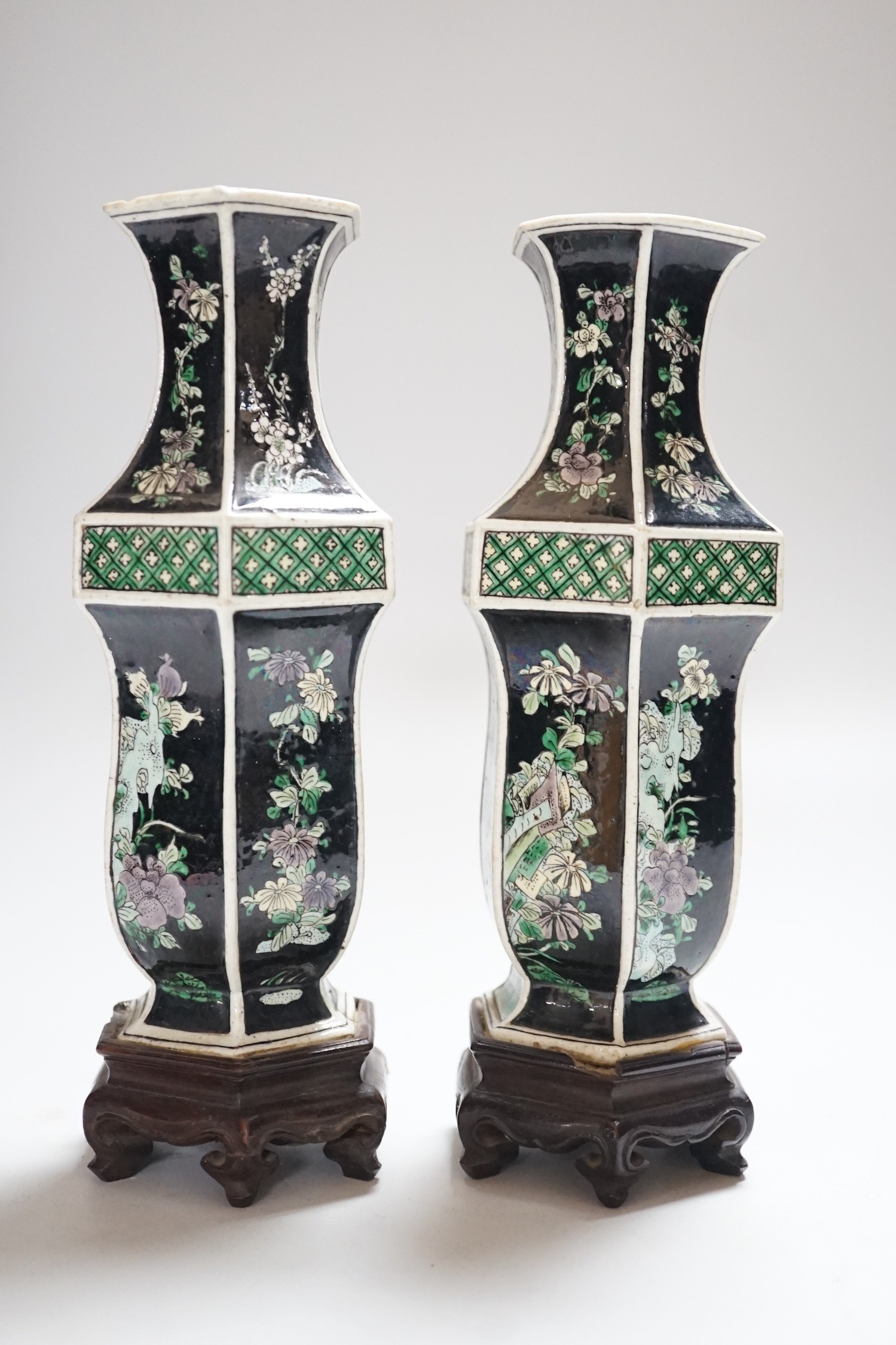 A pair of Chinese famille noire hexagonal vases, late 19th century, wood stands, 21cms high including stands